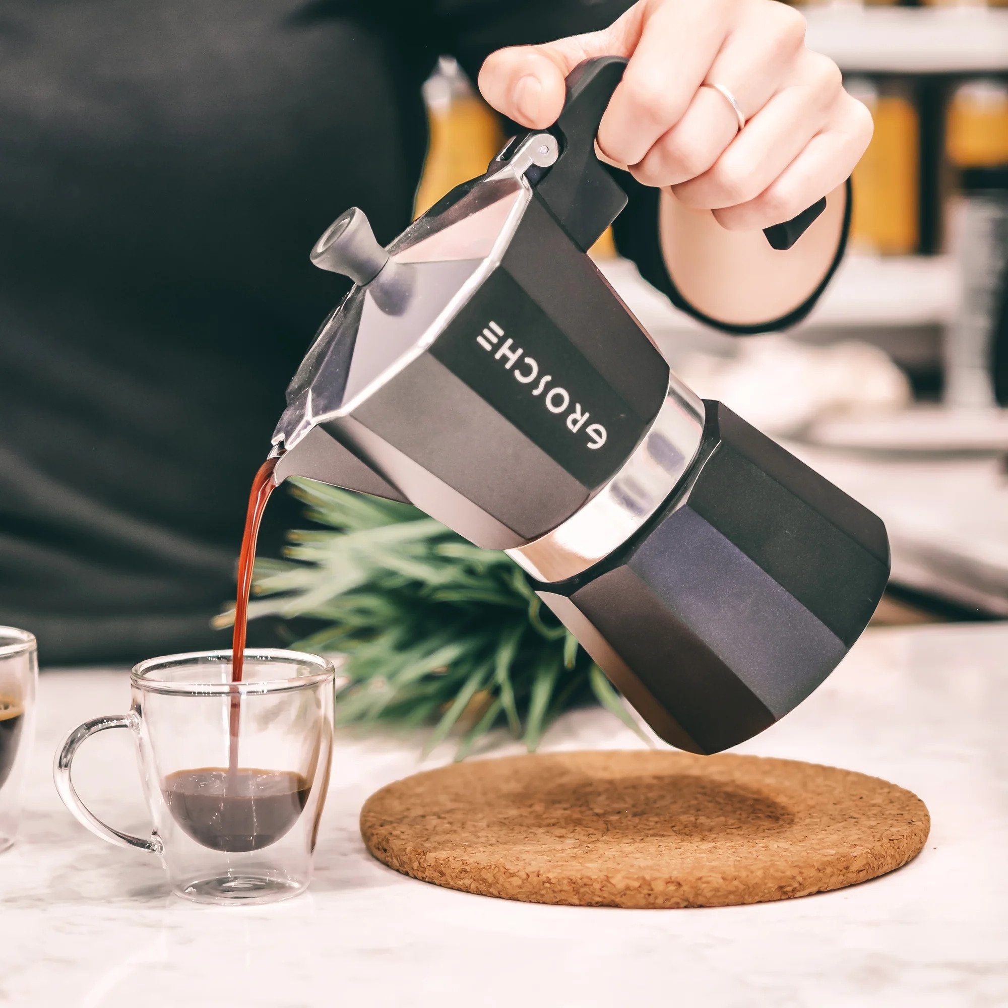 A person pouring espresso out from the percolator