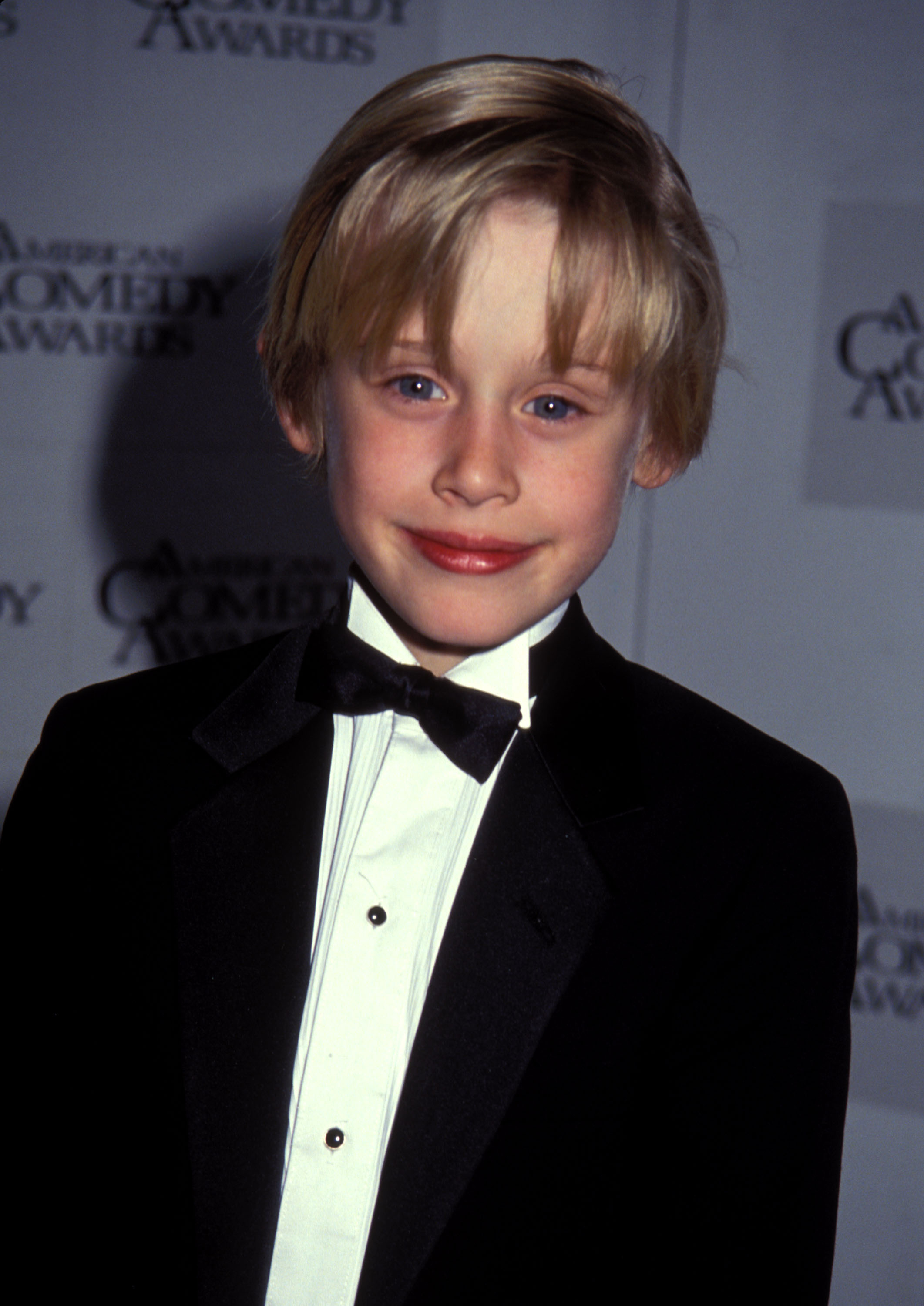 young macaulay in a suit