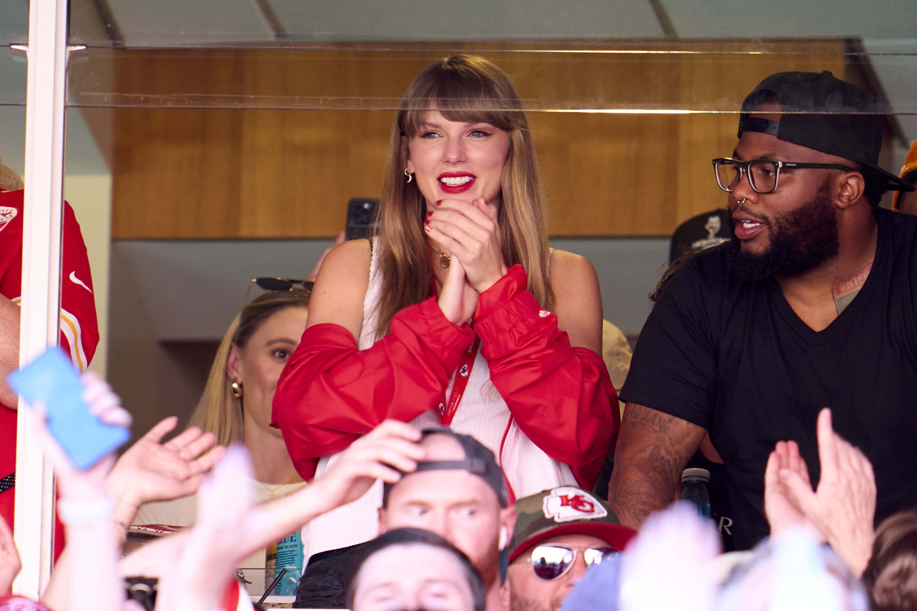 Taylor Swift clapping her hands at a football game