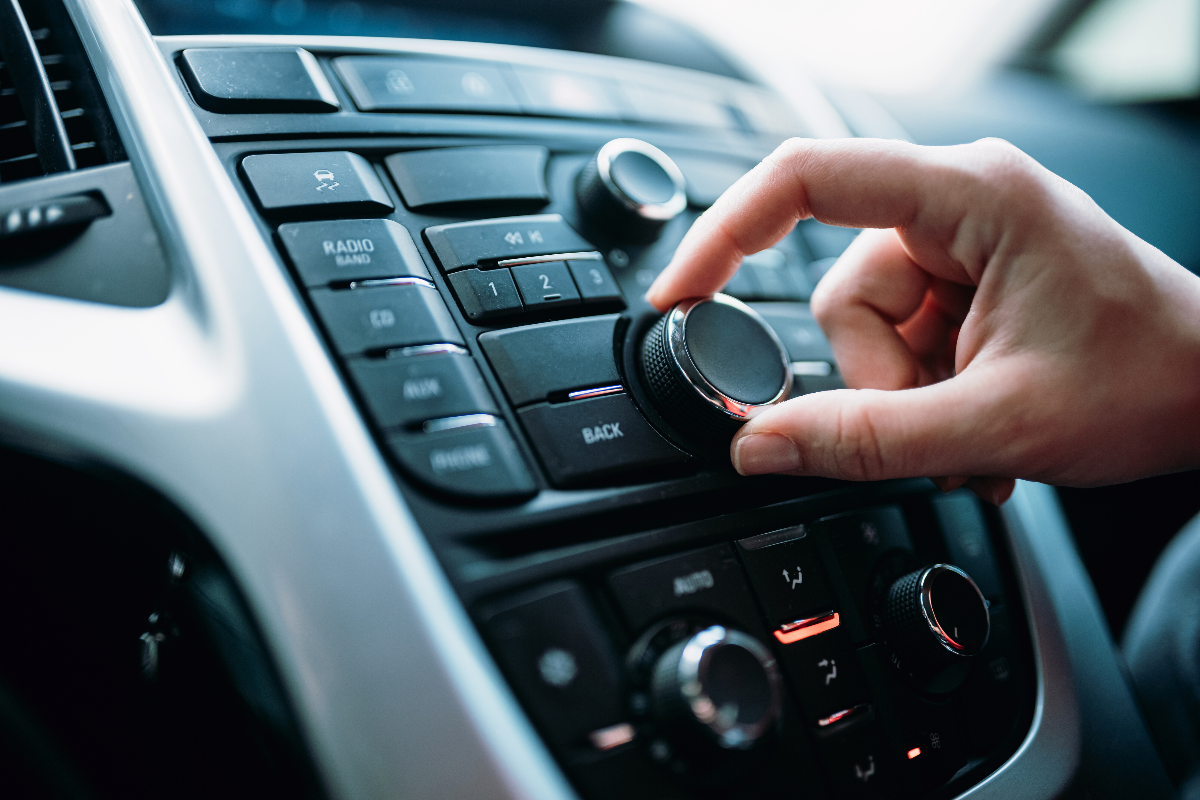 A hand using a car radio