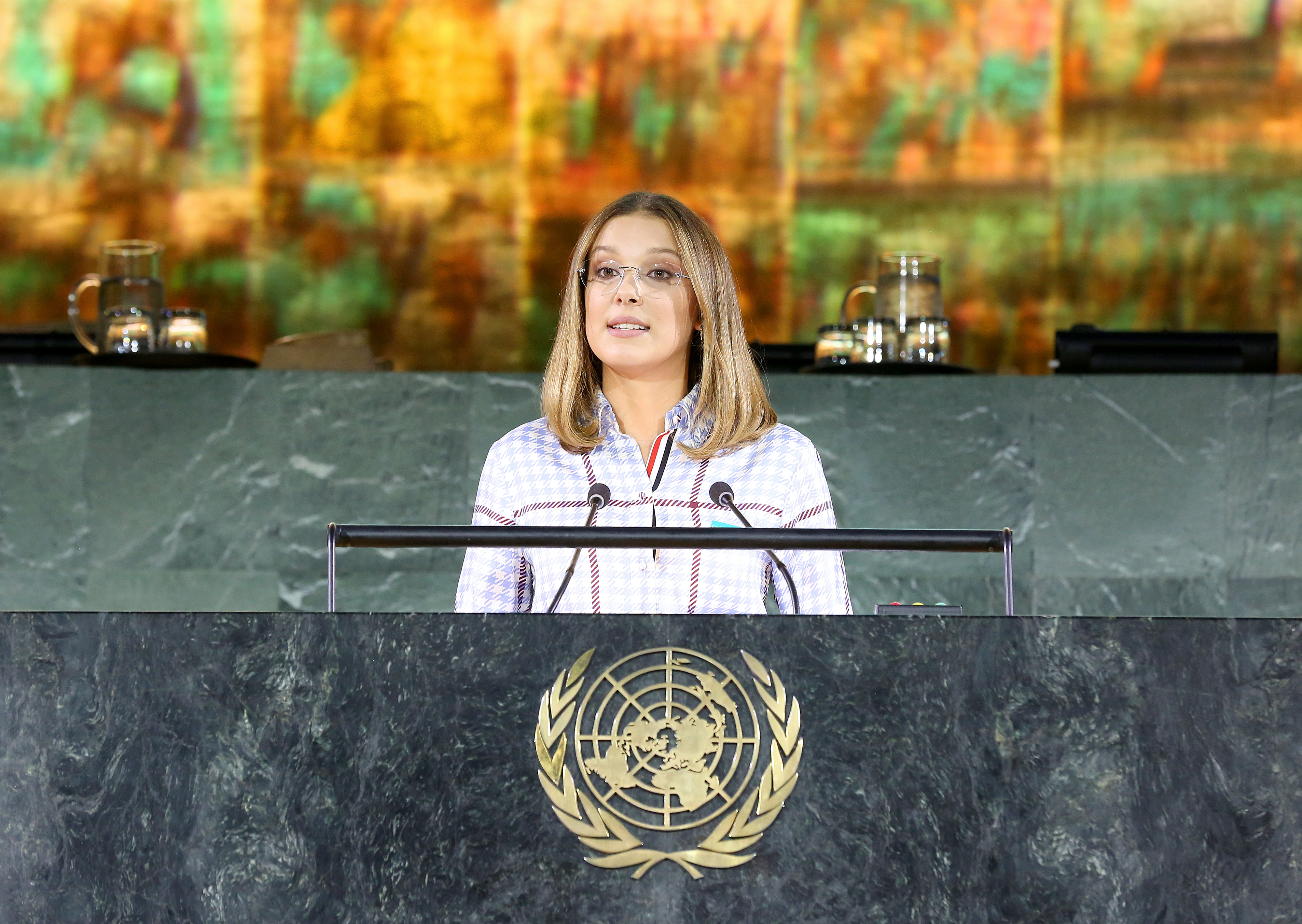 millie giving a speech behind the podium for unicef