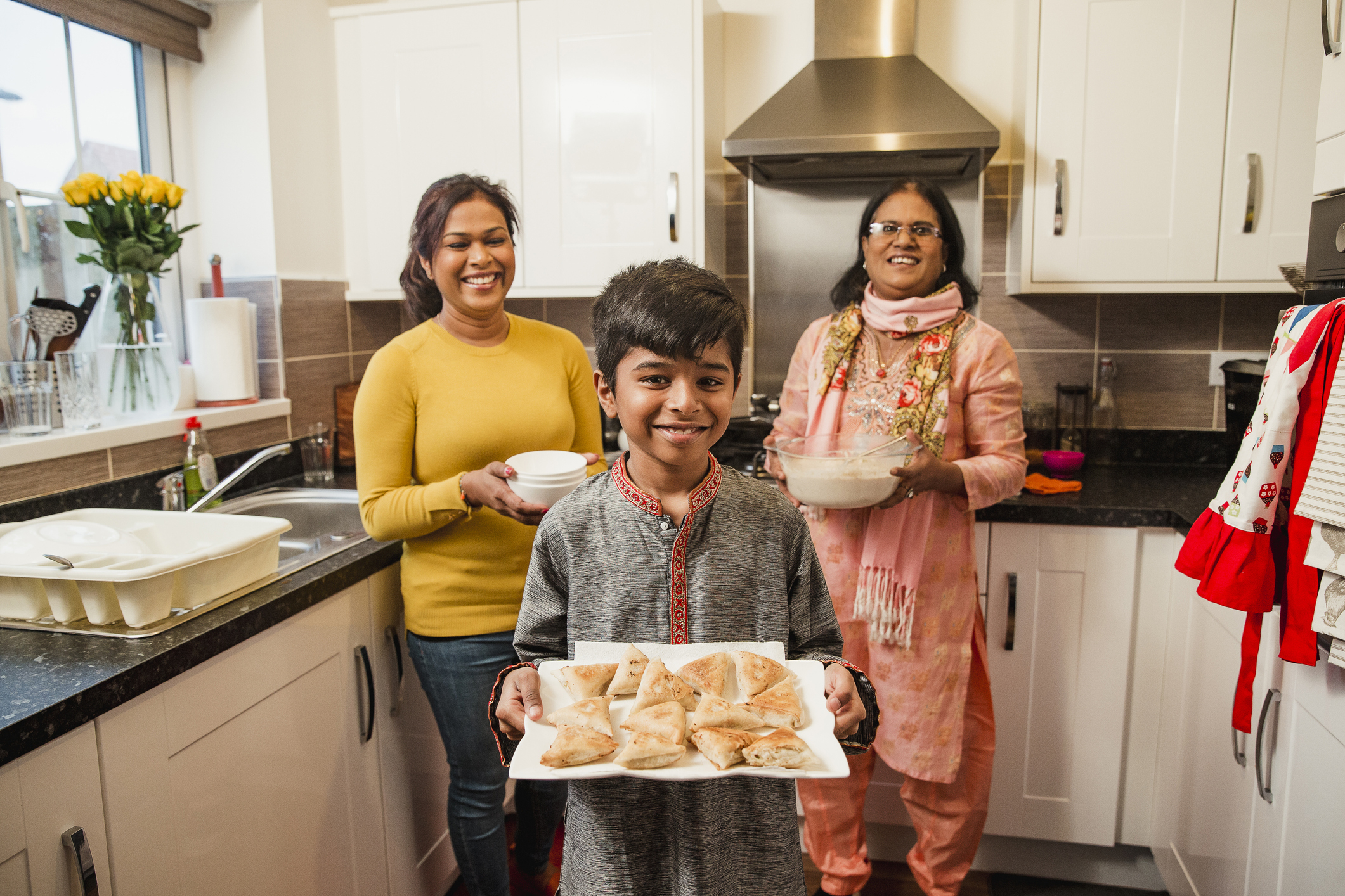 Boy holds food that he&#x27;s helped prepare with his family