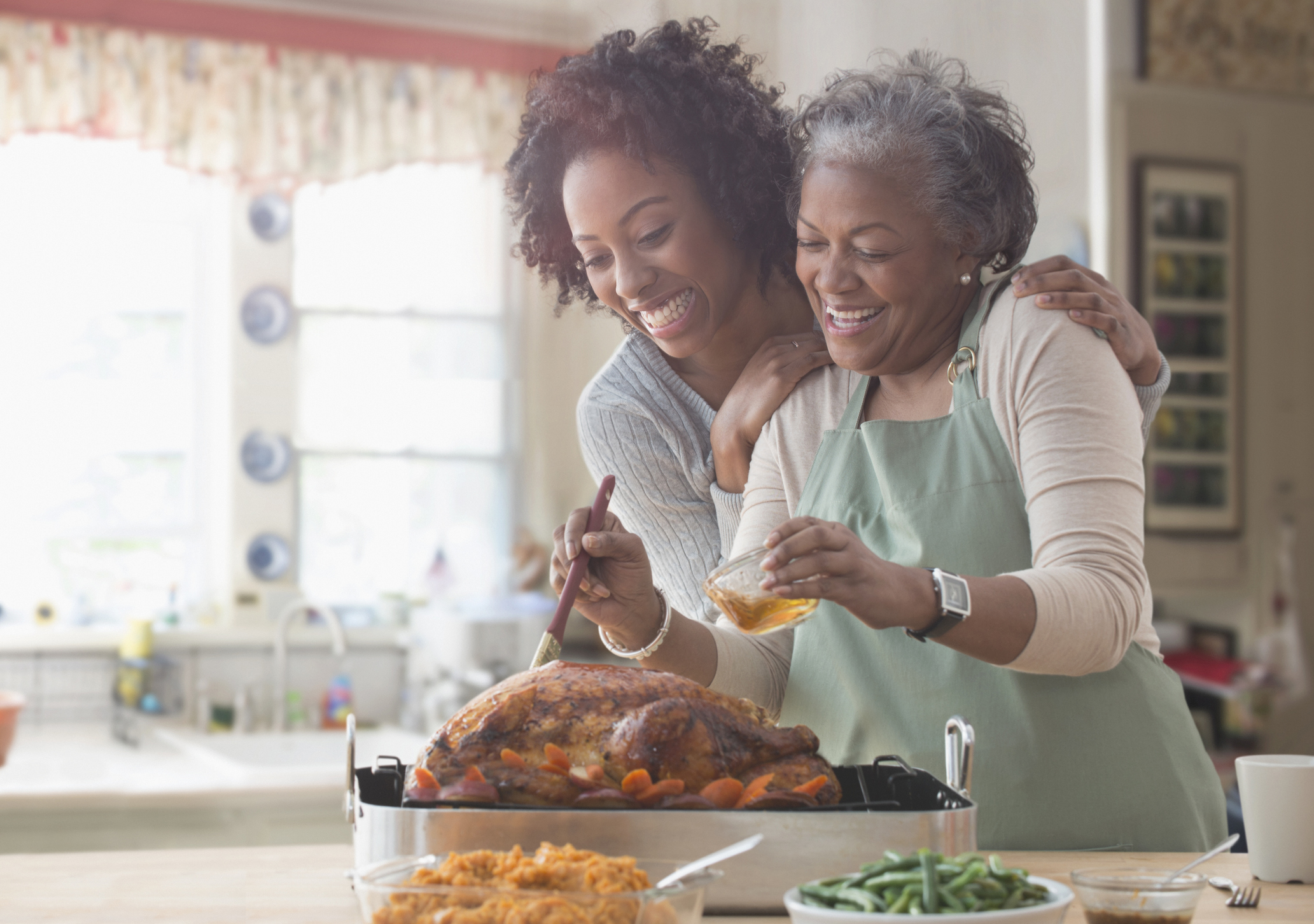 Mother and daughter cook turkey together