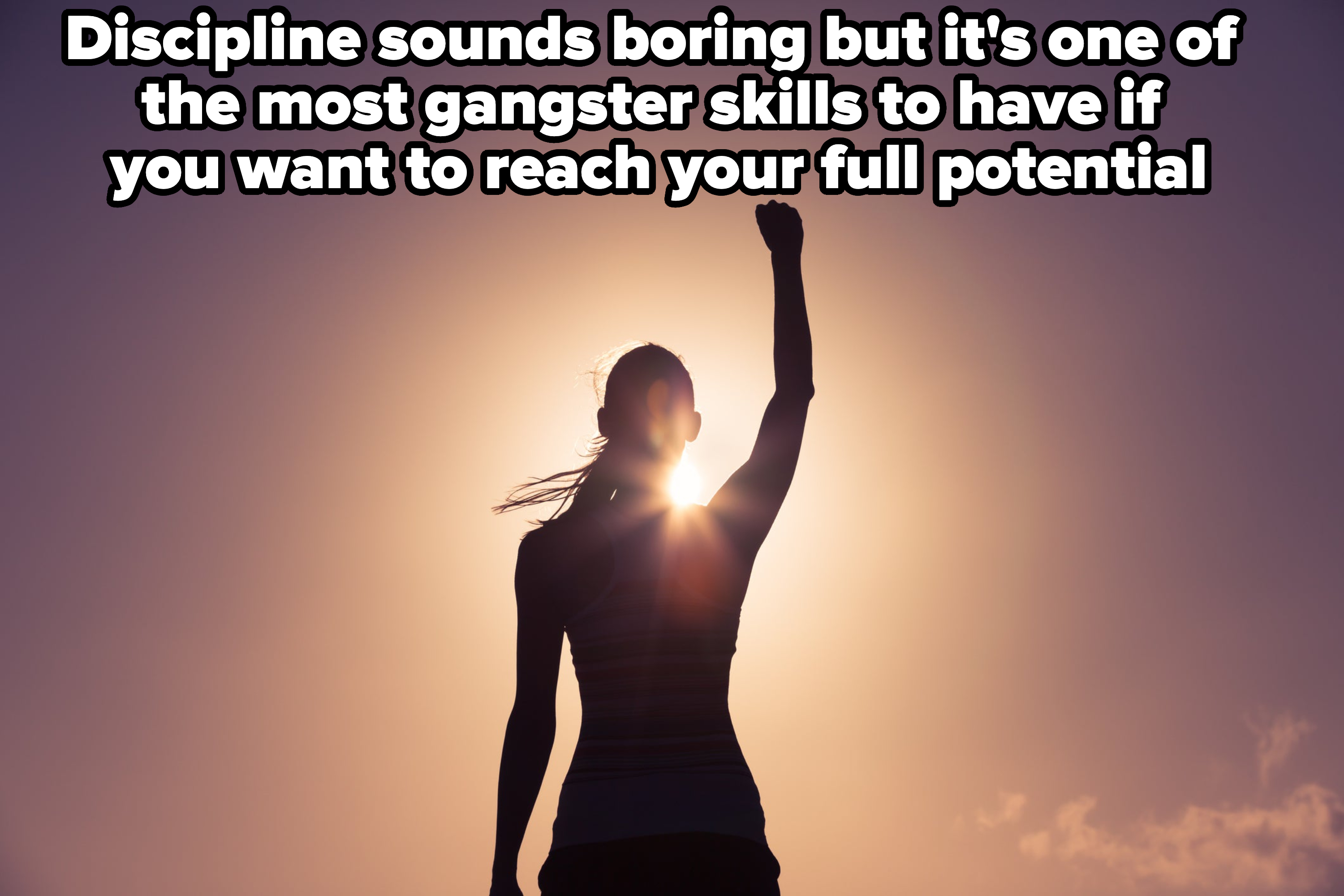 A woman's silhouette against the sun, raising her fist