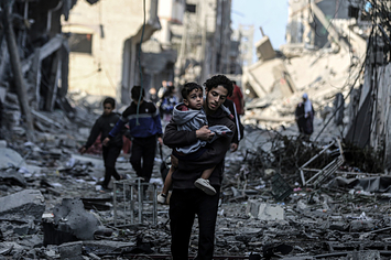 イスラエル軍の砲撃後、がれきの中を非難するガザ市の住民たち（10月16日撮影、Getty Images）