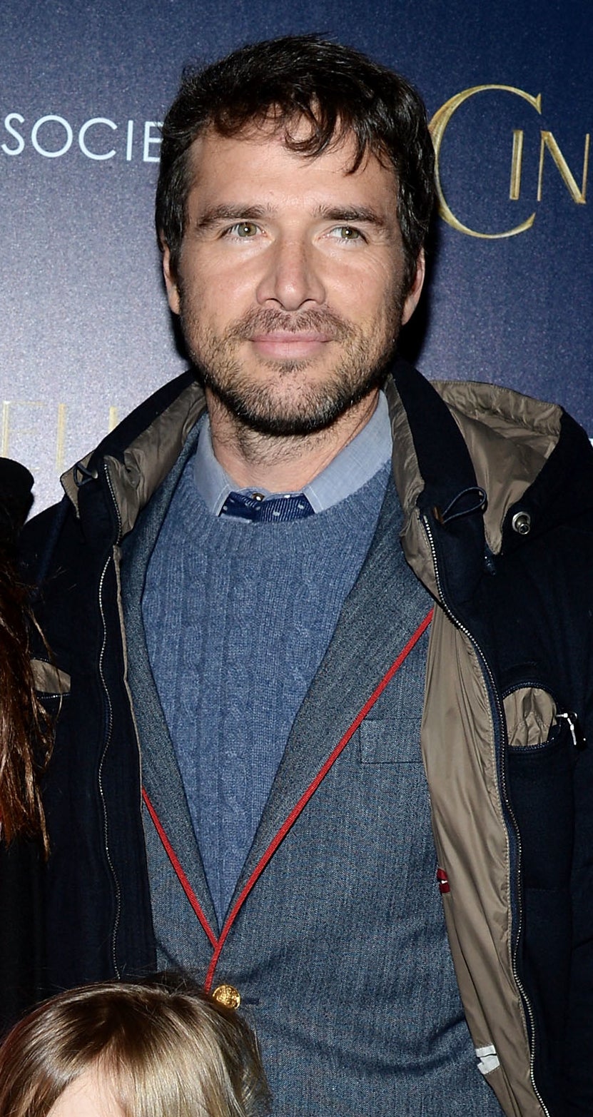closeup of him in a suit underneath a large jacket