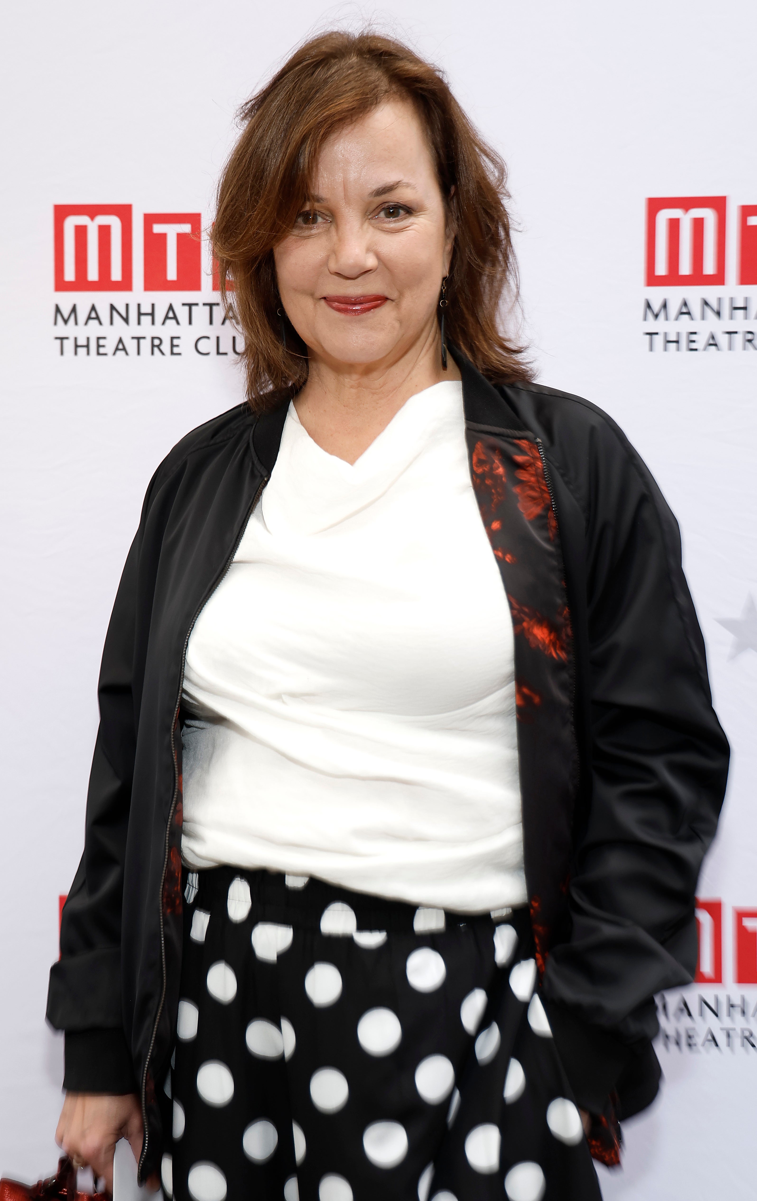 she's wearing polka dot pants and a bomber jacket