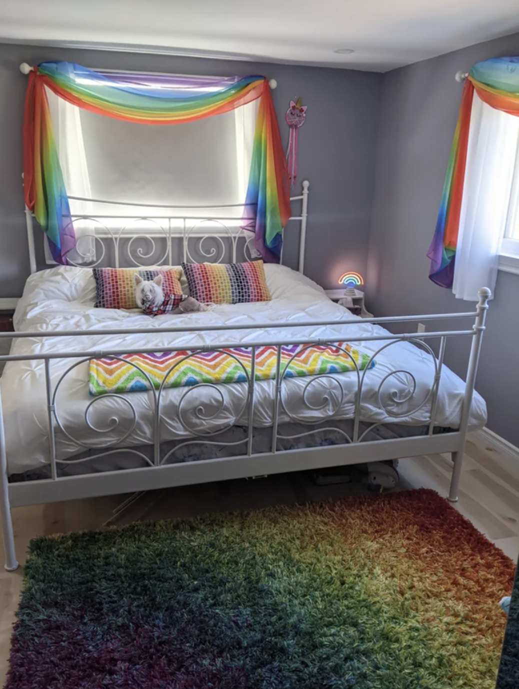 This rainbow-themed room includes rainbow curtains, a rainbow rug, and rainbow pillows