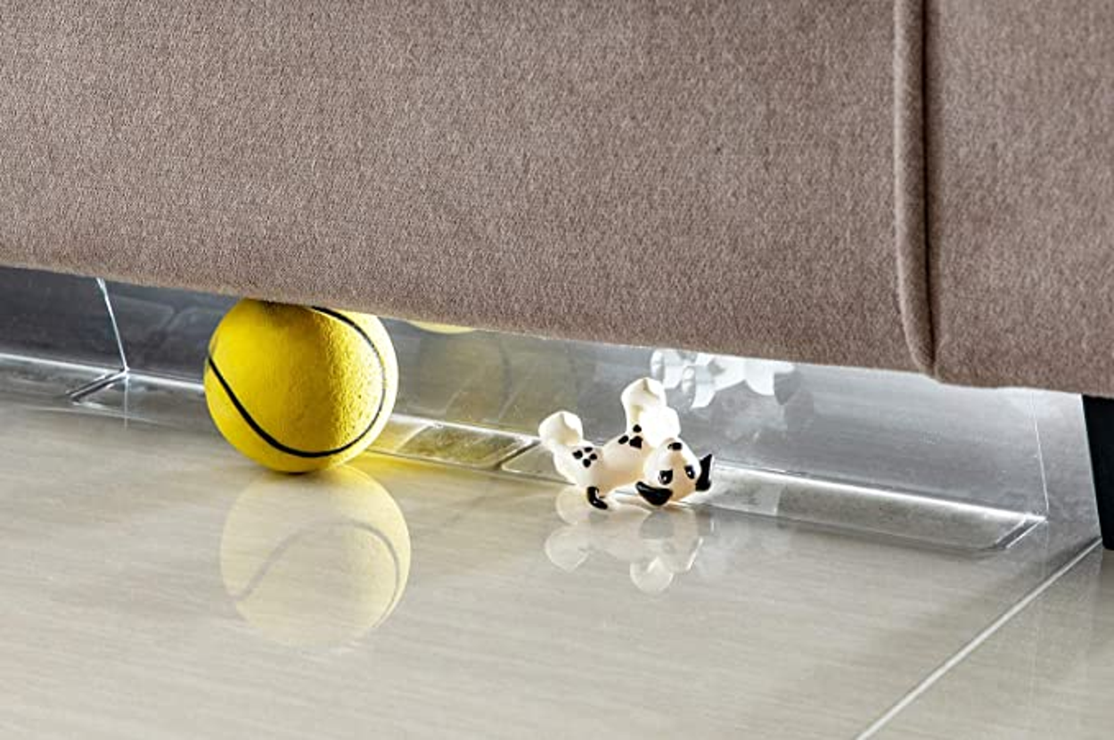 Toys being stopped by the blocker from rolling under the couch