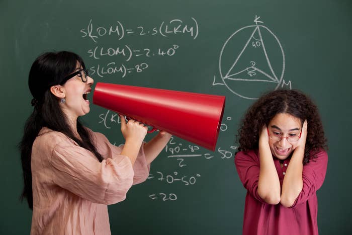 A teacher yelling at a student through a megaphone