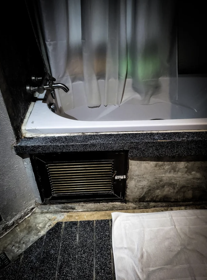 A locked grill under a bathtub