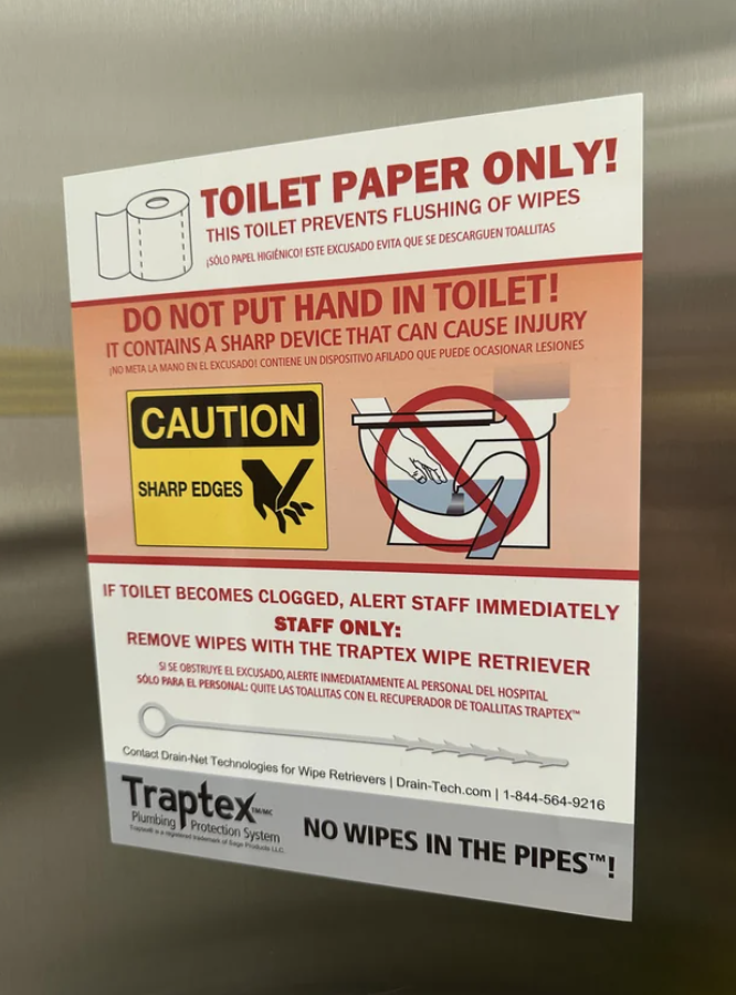 A complicated sign warning people to put only toilet paper in the toilet and don&#x27;t put their hands in it because it contains a sharp device; staff must use &quot;the Traptex wipe retriever&quot; to remove wipes
