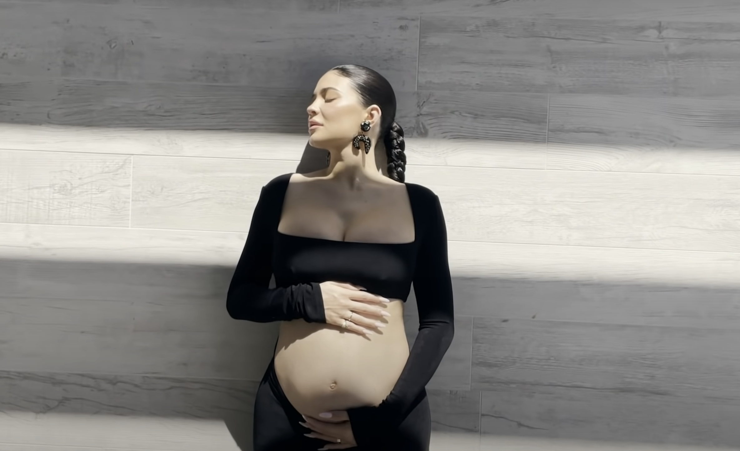Close-up of a pregnant Kylie baring her midriff