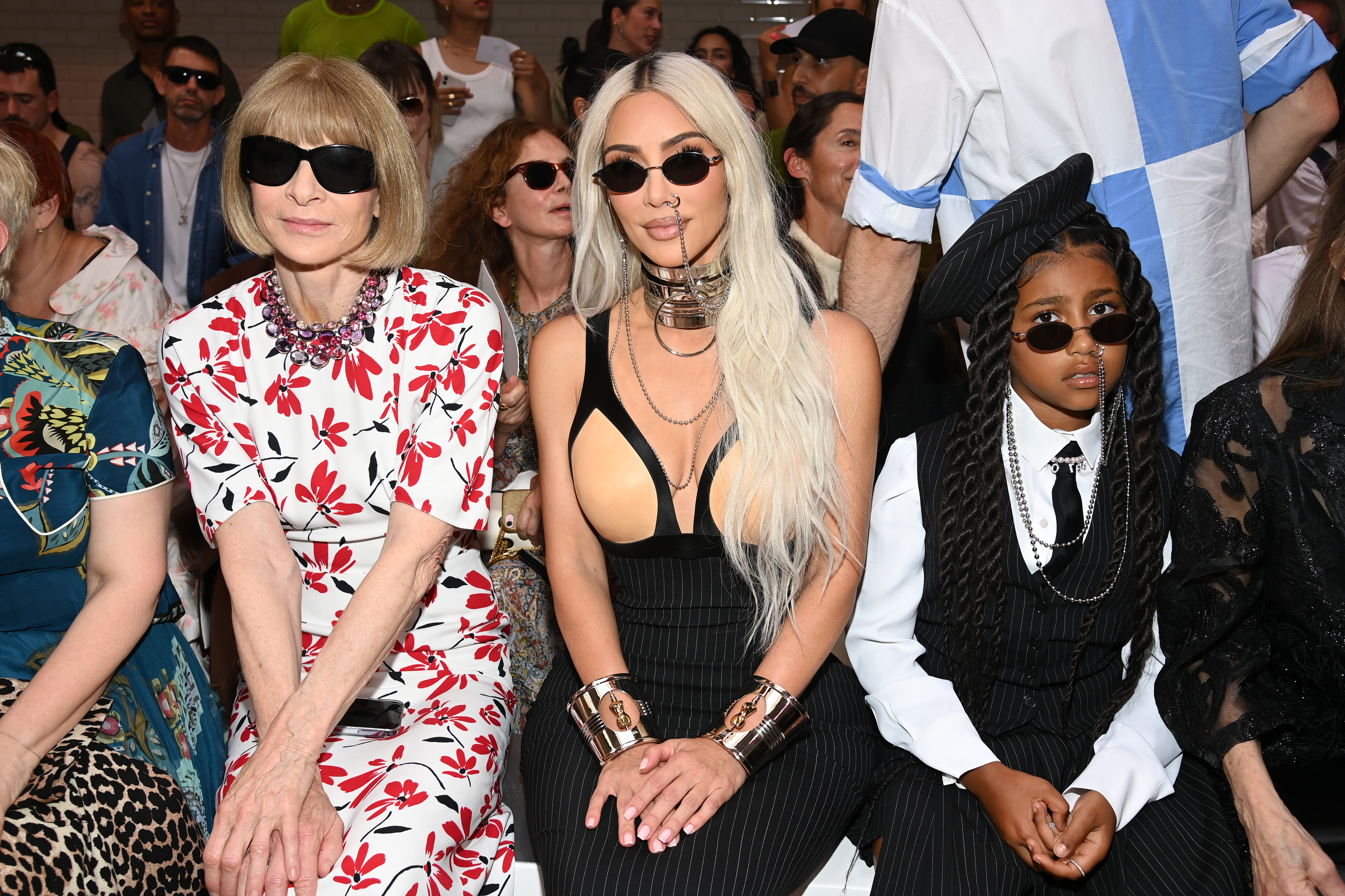 Anna Wintour, Kim, and North sitting together at a runway show