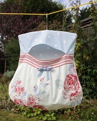 A homey, floral garment holder hanging from a clothesline
