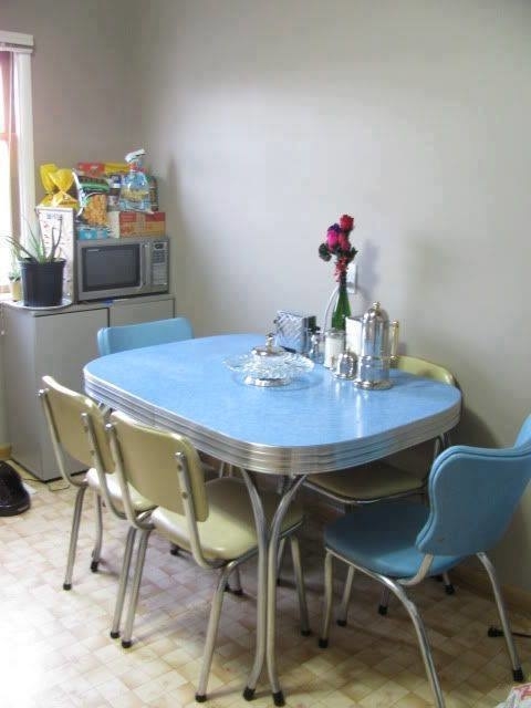 A small rectangular metal table with four armless metal chairs