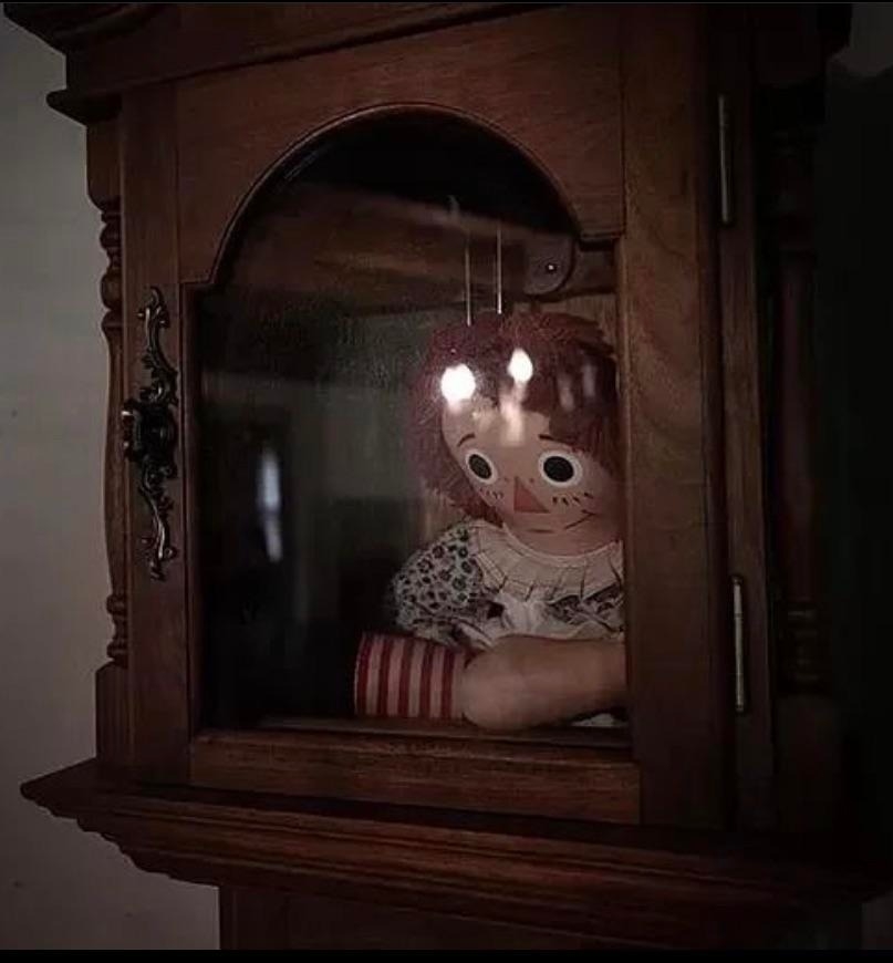 A Raggedy Ann doll in a glass case