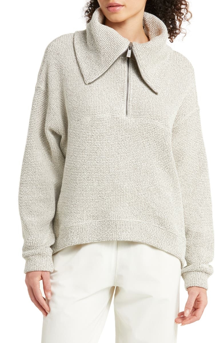 a model wearing the half zip pullover in cream