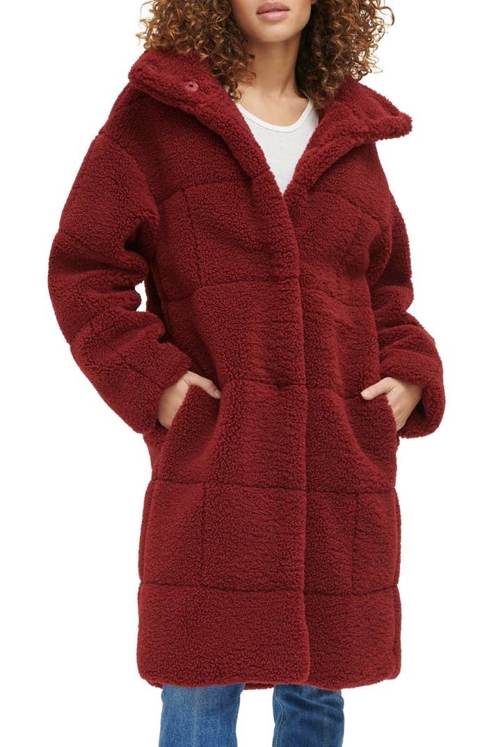 a model wearing the knee length teddy coat in a wine cabernet color