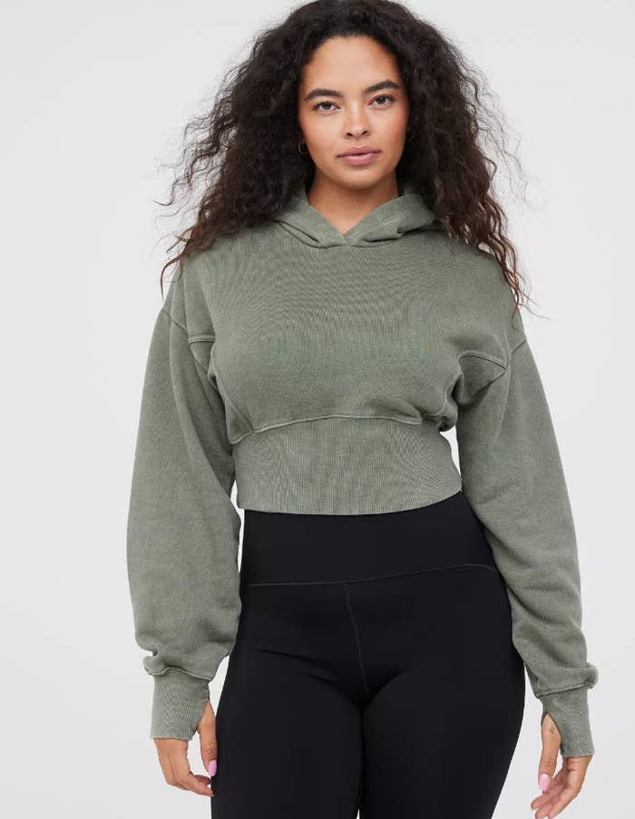 model wearing a distressed green crop hoodie sweater