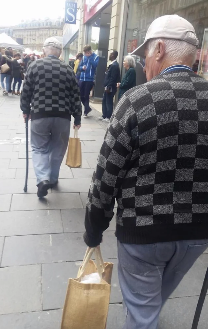Two men on the street wearing the same sweater