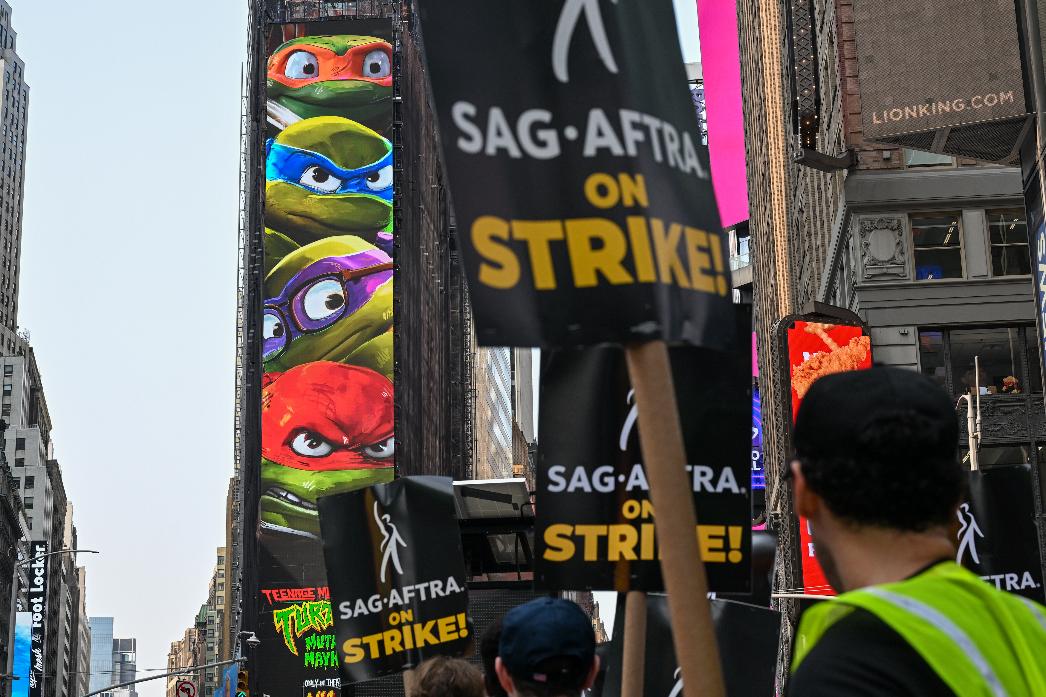 the ninja turtles on a big screen in new york while actors are on strike
