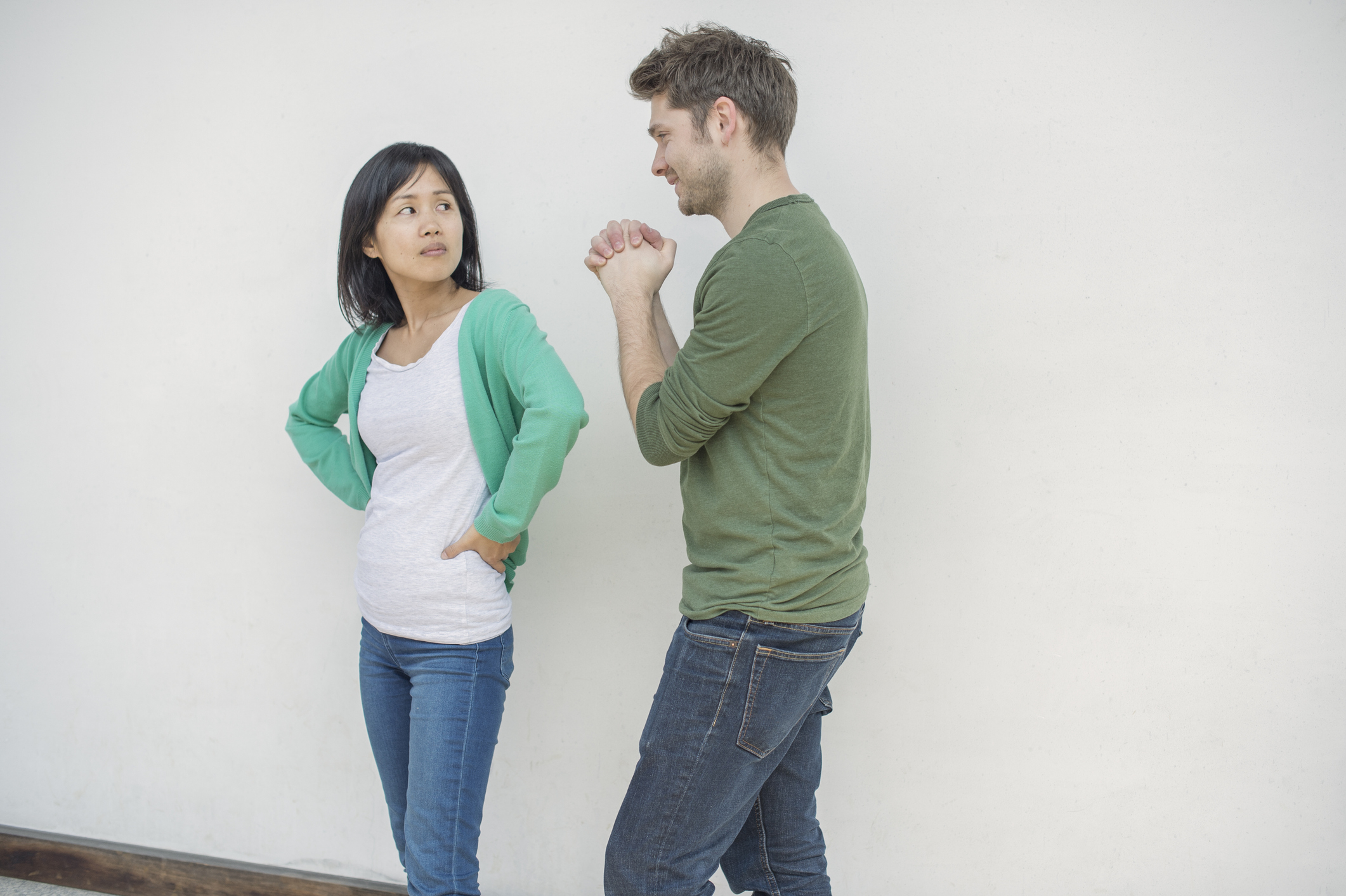 An irritated woman looking at a smiling man