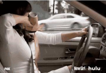woman spilling coffee on herself while driving