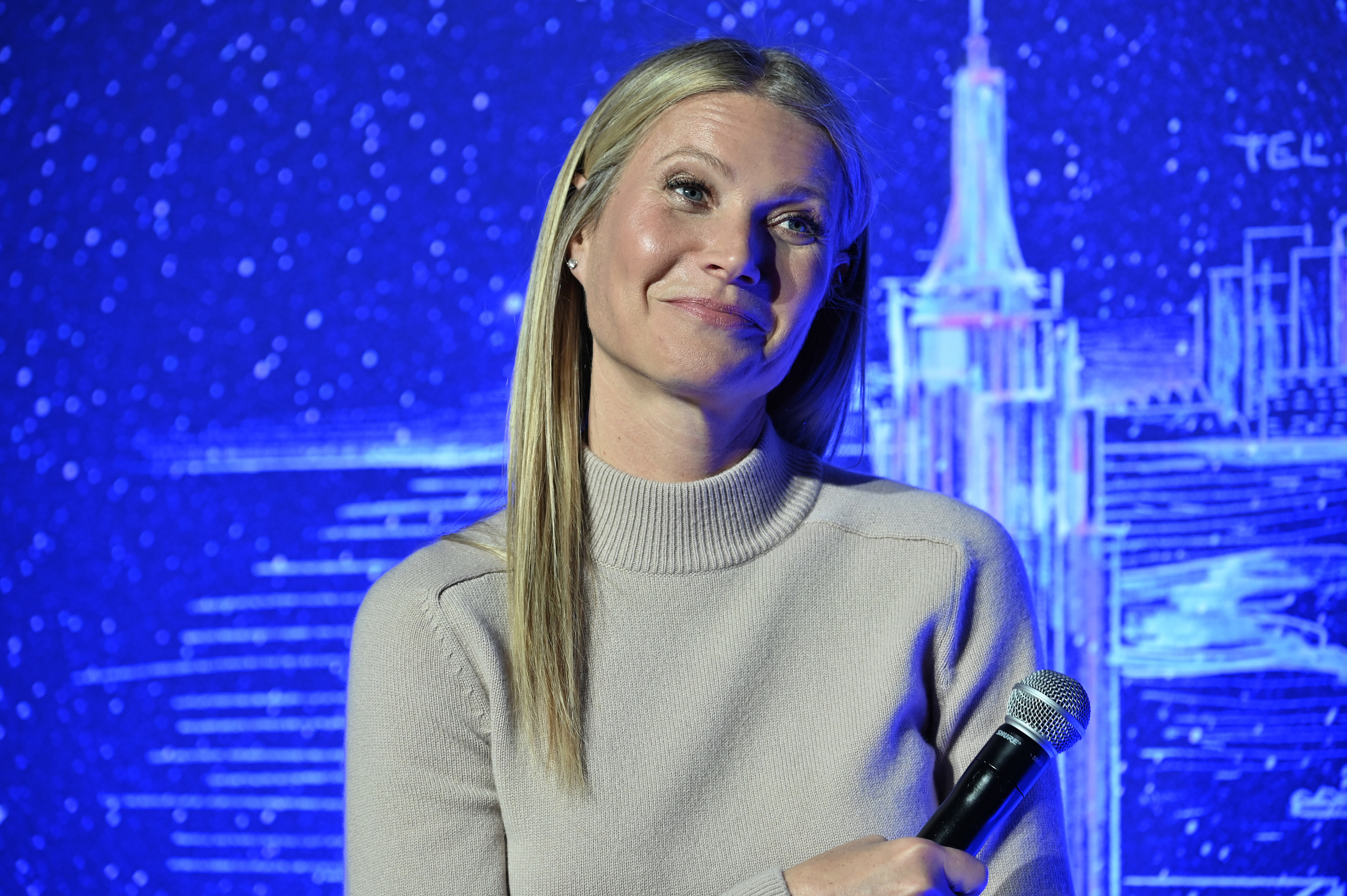 Close-up of Gwyneth smiling and holding a microphone