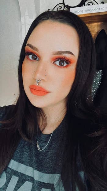 reviewer wearing an orange shade of the lippie
