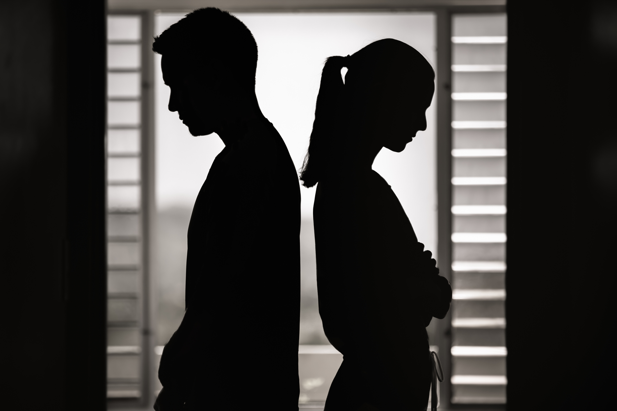 Silhouettes of a couple facing away from each other