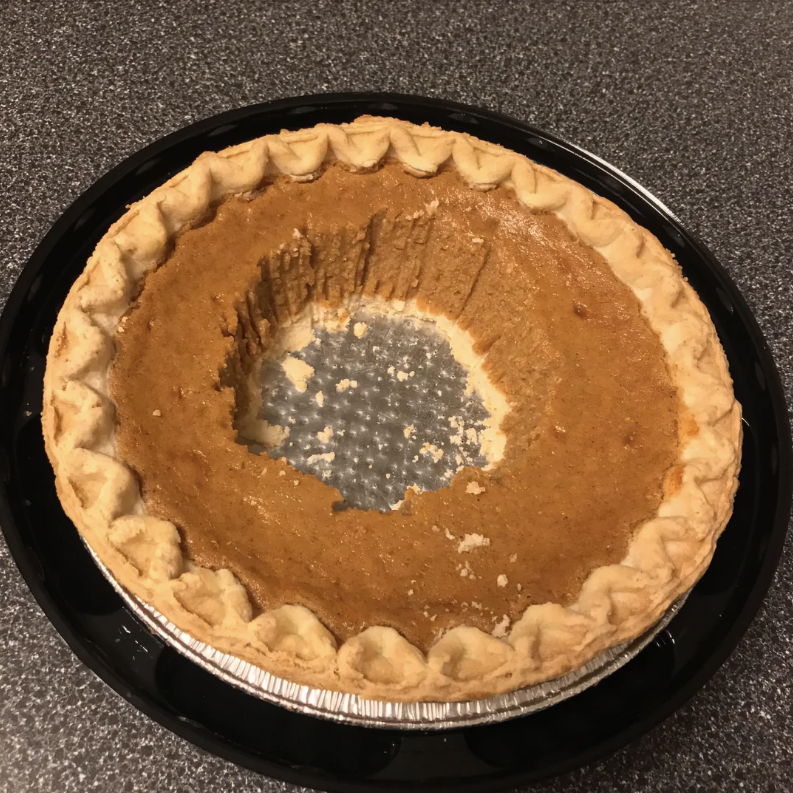A pumpkin pie with a large hole in the middle