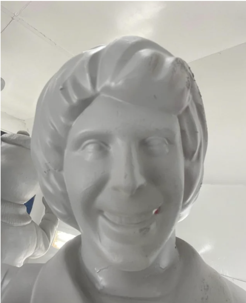 A Ronald McDonald statue with no paint on it