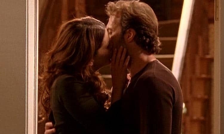 Lorelai caresses Luke&#x27;s cheek as they kiss in a doorway