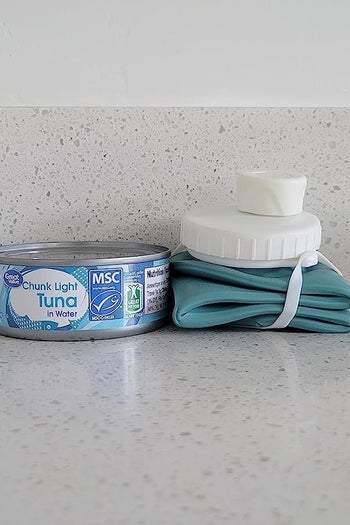 The water bottle folded down next to a can of tuna