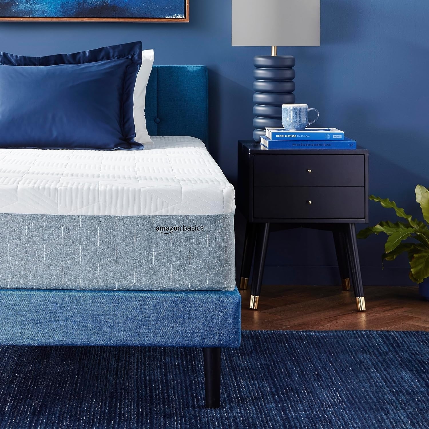 The thick mattress on top of a blue bed frame