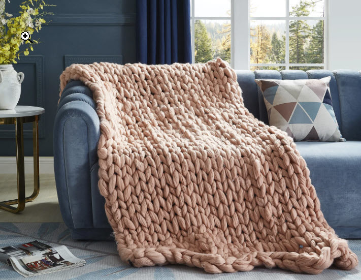 peach colored knit throw blanket sitting over couch