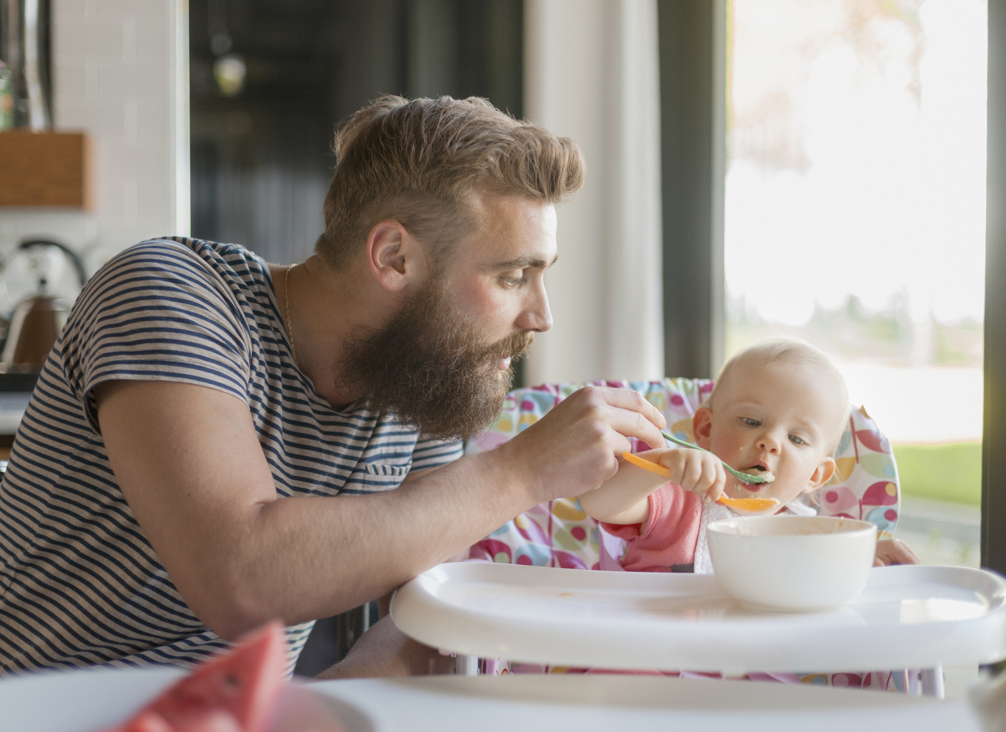 A man feeding his baby