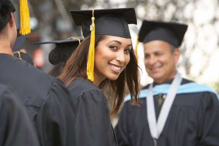 A graduate smiling at the camera