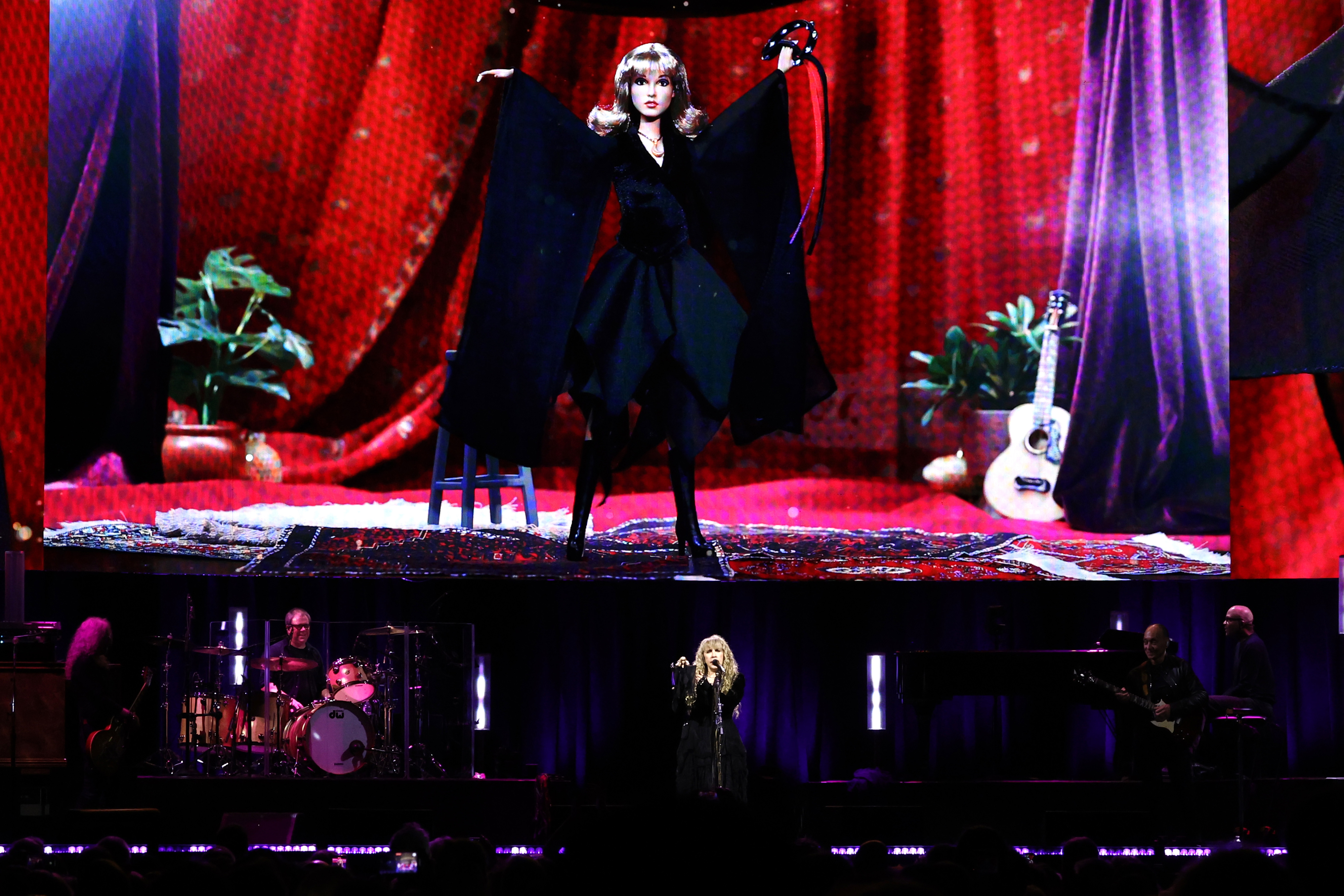 Stevie Nicks onstage with the Barbie doll on a screen above her