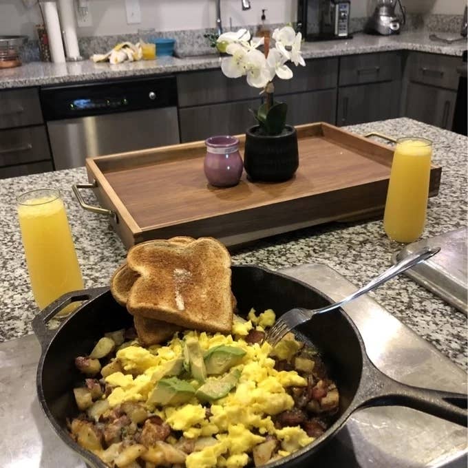 Reviewer image of a an egg skillet hash with toast in the cast iron skillet on their kitchen island