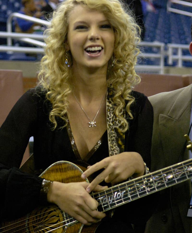 Close-up of Taylor smiling and holding a guitar