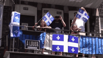 French Canadian family holds a lot of Quebec flags.