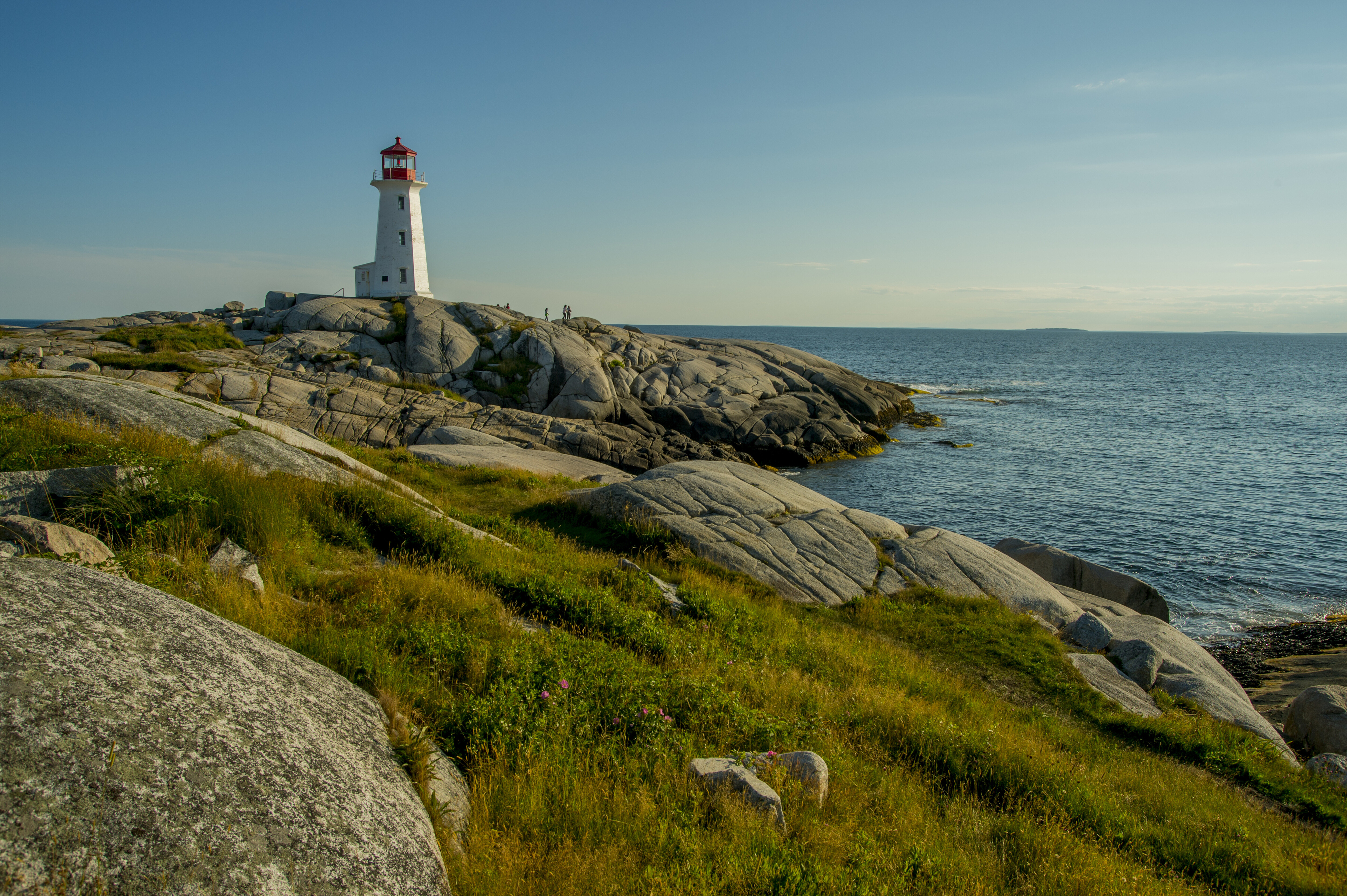Lighthouse in Nova Scotia looks over ocean.