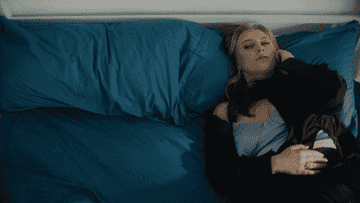 a girl alone in bed turning over to an empty spot