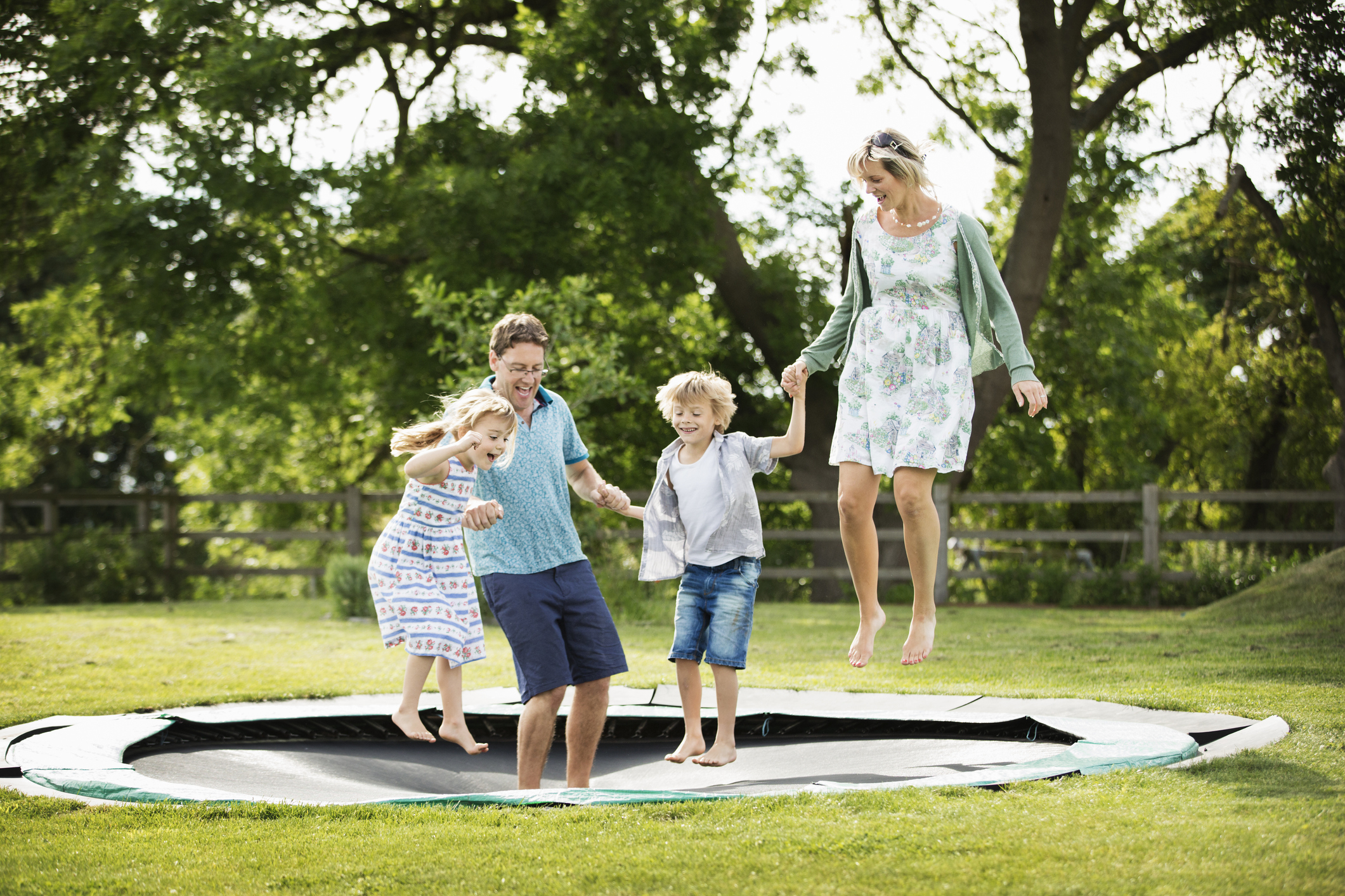 a family jumping on an in-ground trampoline
