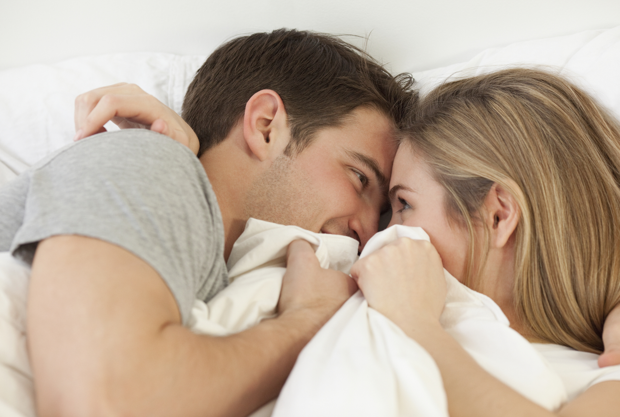 A couple snuggling in bed