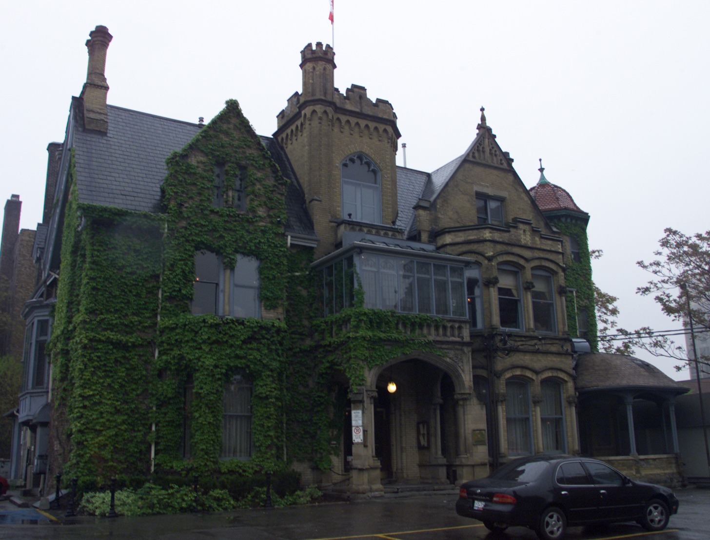 Victorian building partially covered in ivy.