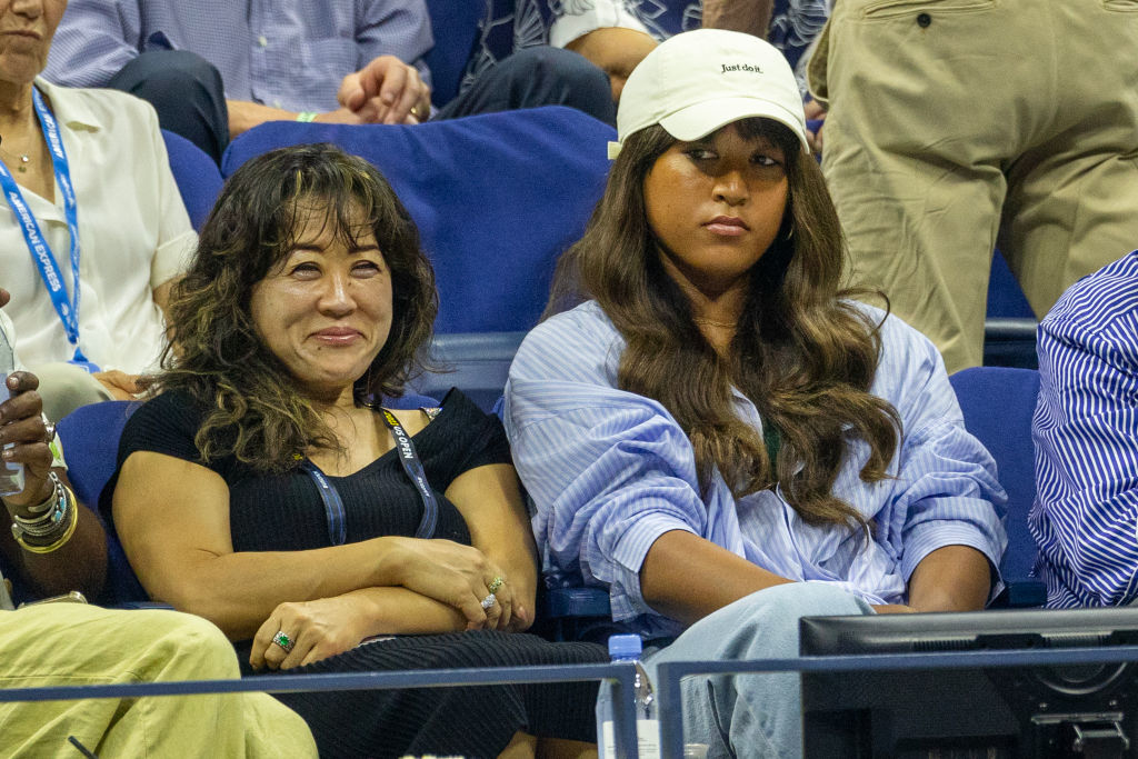 Naomi sitting in the audience in a sports arena
