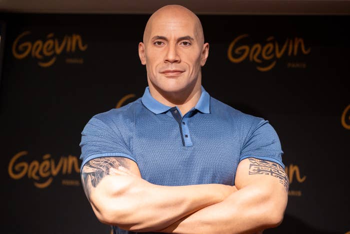 Close-up of The Rock wax figure with arms folded